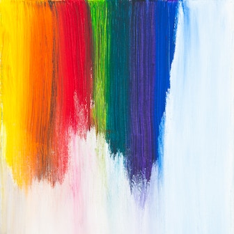 Paint strokes in different colors down a white wall.