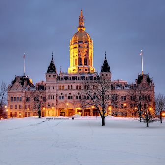 The Connecticut State Capitol building with snow on the ground.