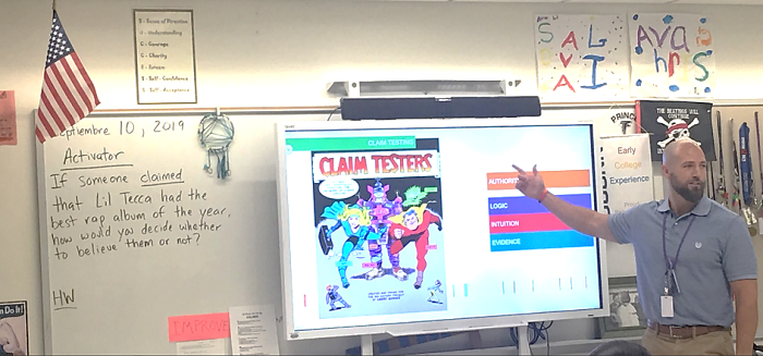 teacher, Mr. Morgan pointing to whiteboard 