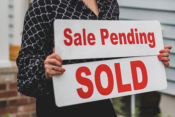 person holding real estate sign