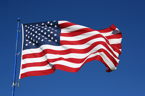 A large United States of America flag waving in the wind.