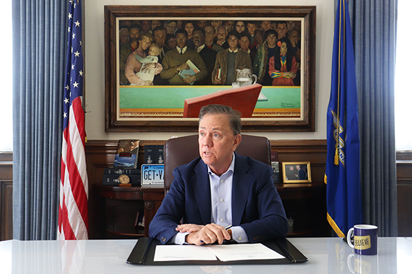 Governor Lamont sitting at his desk.