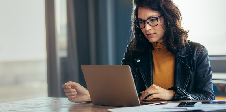 Woman scrolling on a laptop